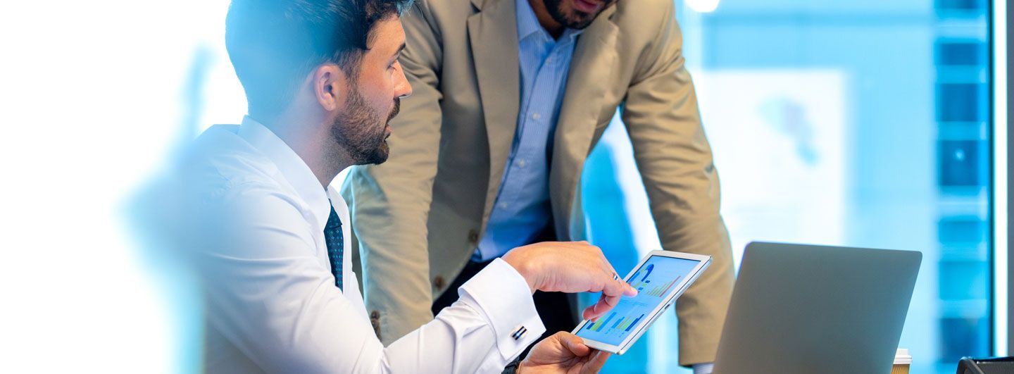 Men talking over tablet